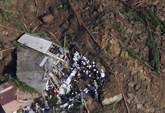 Firefighters are seen trying to rescue missing persons at the scene of a major landslide from a Mainichi Shimbun helicopter in Nakatsu, Oita Prefecture, on April 11, 2018. (Mainichi)